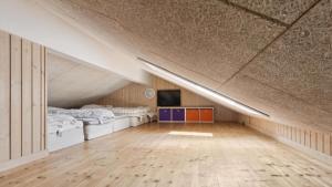 una camera da letto mansardata con due letti e una televisione di Villavilla #292 - Søndervig, Vestjylland a Klegod