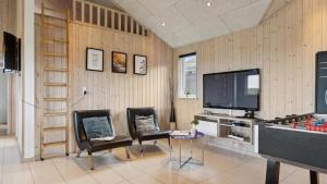 un soggiorno con 2 sedie e una TV di Villavilla #292 - Søndervig, Vestjylland a Klegod