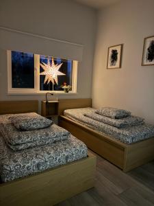 ein Schlafzimmer mit 2 Betten und ein Fenster mit einem Stern in der Unterkunft Krastos - māja Breksis in Aizkraukle