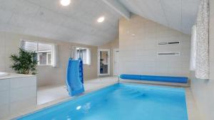 een groot zwembad in een witte kamer met een blauw bad bij Villavilla #508 - Mommark, Sydjylland in Sarup