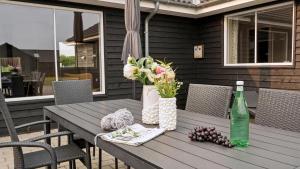 een houten tafel met bloemen en een fles wijn bij Villavilla #508 - Mommark, Sydjylland in Sarup