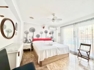 een witte slaapkamer met een bed en een spiegel bij Macarena House & Chill Out in Benidorm