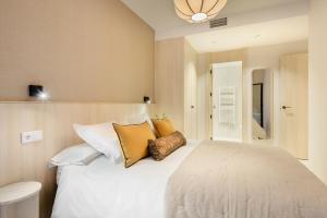 una camera da letto con un grande letto bianco con cuscini di Cima Panticosa by BeValle a Panticosa