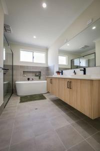 a large bathroom with a tub and a large mirror at Isla Escape Pet Friendly Dunsborough in Dunsborough +27 photos