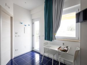 ein Esszimmer mit Tisch und Stühlen und einem Fenster in der Unterkunft VENART by AnrealeRooms in Paestum
