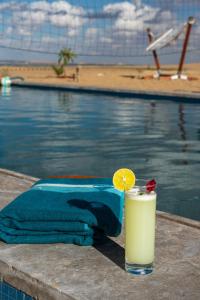 siwa oasisSoléi Desert Retreat的坐在游泳池旁的桌子上喝一杯 更多27张照片