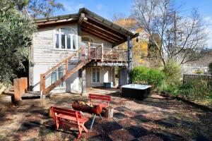 a house with two red benches in front of it at Leura Haven Rustic Mountain Cottage in Leura