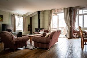 a living room with chairs and a table and a fireplace at Leura Haven Rustic Mountain Cottage in Leura