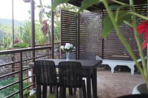a table with chairs and a vase of flowers on a patio at Balay Degay Transient House in Baguio