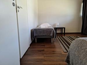 a room with a bed and a table with a blanket at Spacious Apartment for 5 in Sodankylä