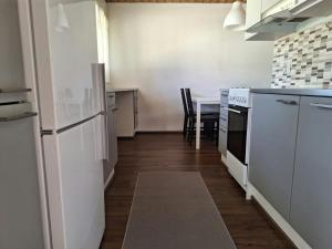 a kitchen with a white refrigerator and a table at Spacious Apartment for 5 in Sodankylä +2 photos