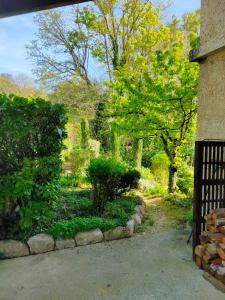 ein Tor zu einem Garten mit Bäumen und Sträuchern in der Unterkunft La clairière in Pierrelongue