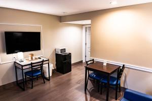 亨廷顿Whitman Motor Lodge的有桌椅和电视的房间 更多3张照片