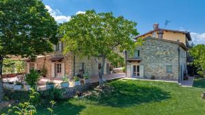 een extern uitzicht op een stenen huis met een tuin bij Tenuta Seriole 10 in Bibbiena