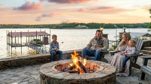 een groep mensen die rond een vuurkorf zitten bij Gather in Style Space Views & Comfort in Runaway Bay