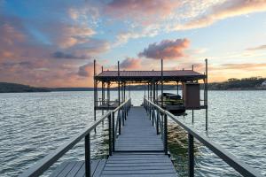 een dok op een meer met een boot erop bij Gather in Style Space Views & Comfort in Runaway Bay