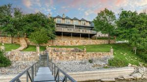 een groot huis op een heuvel met een stenen muur bij Gather in Style Space Views & Comfort in Runaway Bay +36 foto's