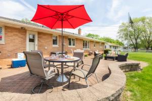 a patio with a table and chairs with a red umbrella at Stadium District Resch 3 BR Sleeps 8 in Green Bay
