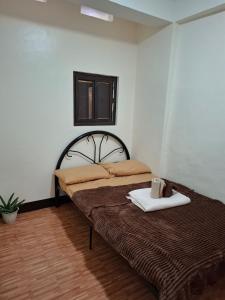 a bedroom with a bed with a towel on it at Balay Degay Transient House in Baguio