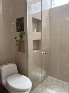 a bathroom with a toilet and a glass shower at 2325 Apartaestudios in Arauca