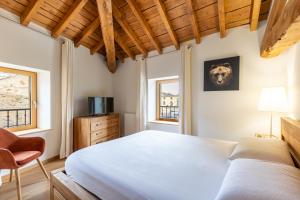 una camera da letto con un letto, una sedia e due finestre di L’Écrin des Angles - Jacuzzi Sauna Hamman privé a Les Angles