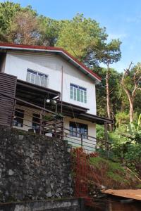 a white house on top of a stone wall at Balay Degay Transient House in Baguio