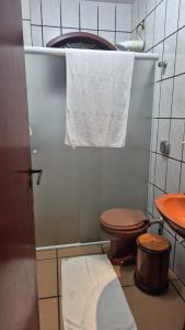 ein kleines Bad mit einem WC und einem Handtuch in der Unterkunft apto 201 in Florianópolis