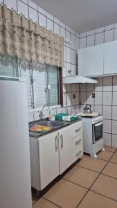 eine Küche mit Spüle und Herd in der Unterkunft apto 201 in Florianópolis