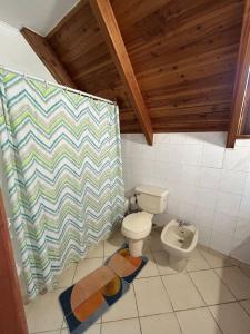 ein Badezimmer mit Toilette und Duschvorhang in der Unterkunft Cabañas Mulpun in Licán Ray