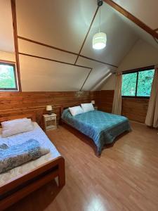 ein Schlafzimmer mit zwei Betten in einem Zimmer in der Unterkunft Cabañas Mulpun in Licán Ray