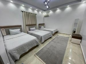 une chambre avec deux lits et un tapis dans l'établissement La Dolce Villa with Private Pool, à Borg El Arab 8 autres photos