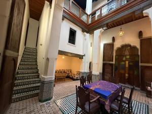 a dining room with a table and stairs in a building at Riad Ranya in Fez
