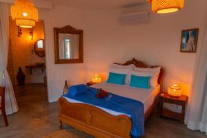 a bedroom with a bed with blue and white pillows at Olymp Spa Boutique Hotel in Monte das Gameleiras +134 photos