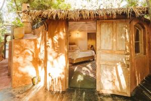 Oasis Garden Marrakech في مراكش: غرفة بها سرير وكوخ من القش به باب