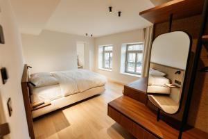 Un pat sau paturi într-o cameră la Alfred Hotel & Gastro Bar