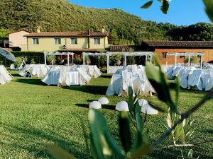 a row of tables with white table settings on a field at Case Vacanza Fiocchi in Arrone