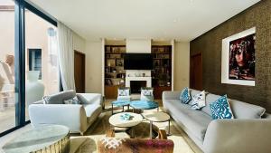 a living room with two couches and a fireplace at Villa Sbaa Marrakech in Marrakesh
