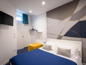 ein Schlafzimmer mit einem blau-weißen Bett und einem gelben Hocker in der Unterkunft VENART by AnrealeRooms in Paestum