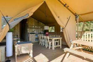 een tent met een tafel en stoelen en een keuken bij Camping 5 étoiles - Piscine - ccbefbi in Gourdon-en-quercy