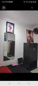 a bedroom with a bed and a dresser and pictures on the wall at Short Let Apartments in Lagos Business School Lekki Ajah in Lekki