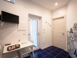 ein Zimmer mit einem Schreibtisch und einem Fernseher an der Wand in der Unterkunft VENART by AnrealeRooms in Paestum + 28 Fotos