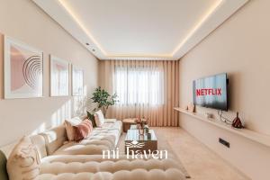 a living room with a couch and a tv at Aura - 1 BR - Premium Apartment in Maarif +2 photos