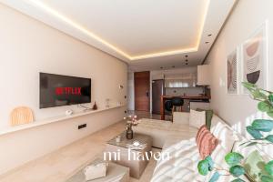 a living room with a couch and a tv at Aura - 1 BR - Premium Apartment in Maarif