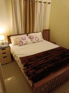 ein Schlafzimmer mit einem großen Bett und Kissen in der Unterkunft Godiva Apartment in Kochi