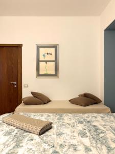 a bedroom with two beds and a picture on the wall at Parirolo B&B in Tresivio