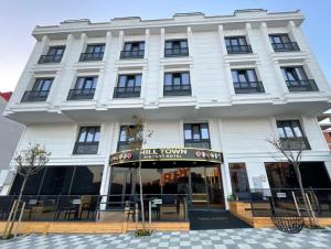 Un gran edificio blanco con una tienda al frente. en HillTown Airport Hotel & Restaurant, en Taşoluk