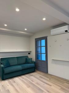 un soggiorno con divano verde e finestra di Lanzo Belvedere - Central Apartment a Lanzo Torinese