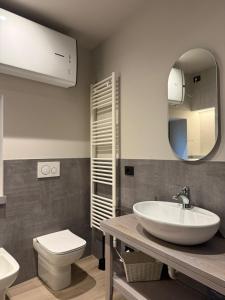 un bagno con lavandino, WC e specchio di Lanzo Belvedere - Central Apartment a Lanzo Torinese