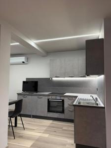una cucina con elettrodomestici in acciaio inossidabile e un tavolo di Lanzo Belvedere - Central Apartment a Lanzo Torinese