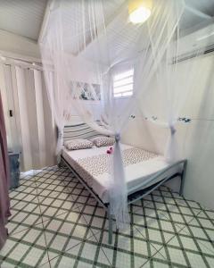 een slaapkamer met een bed met klamboes bij Appartement Oslo in Sainte-Anne +5 foto's